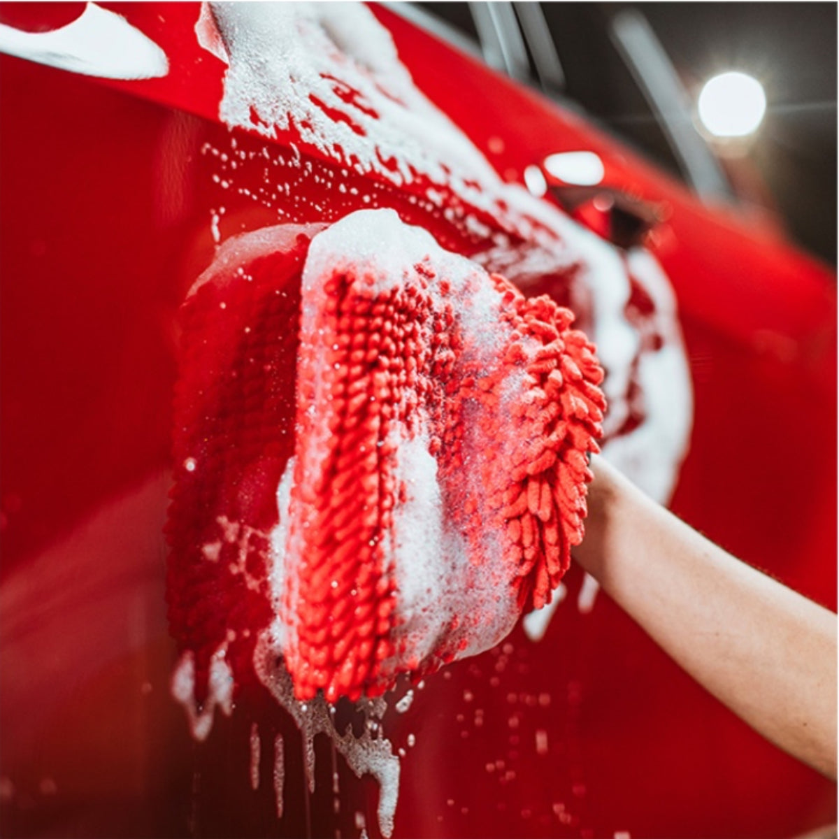 Autoglym Foaming Car Wash Shampoo – hånd med rød vaskevante skrubber skum på rød billak