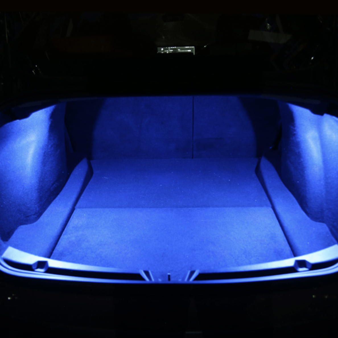 Tesla-bagagerum oplyst af blåt LED-lys i mørke
