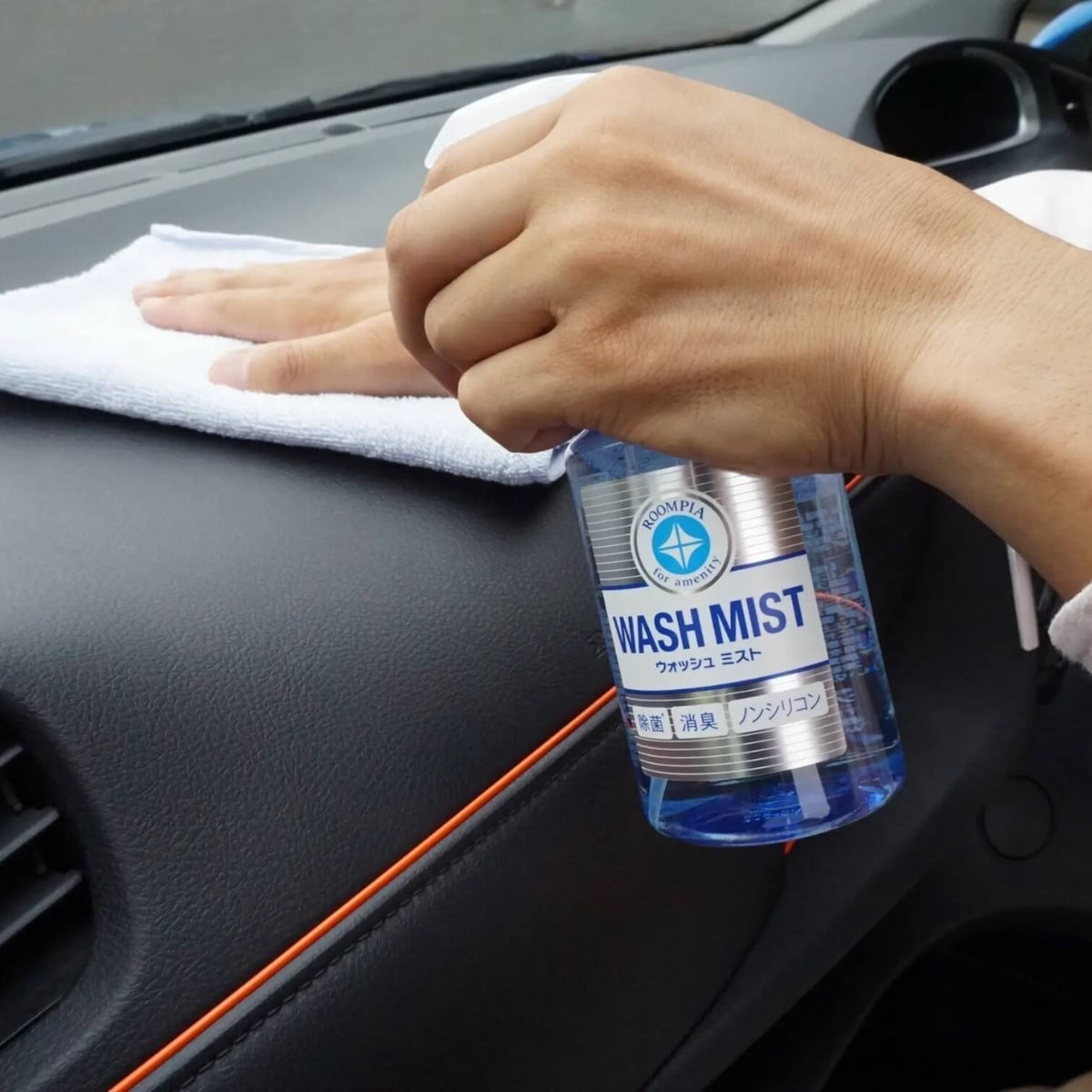 Soft99 Wash Mist interiørrens sprayes på bilens instrumentbræt, som derefter tørres af.