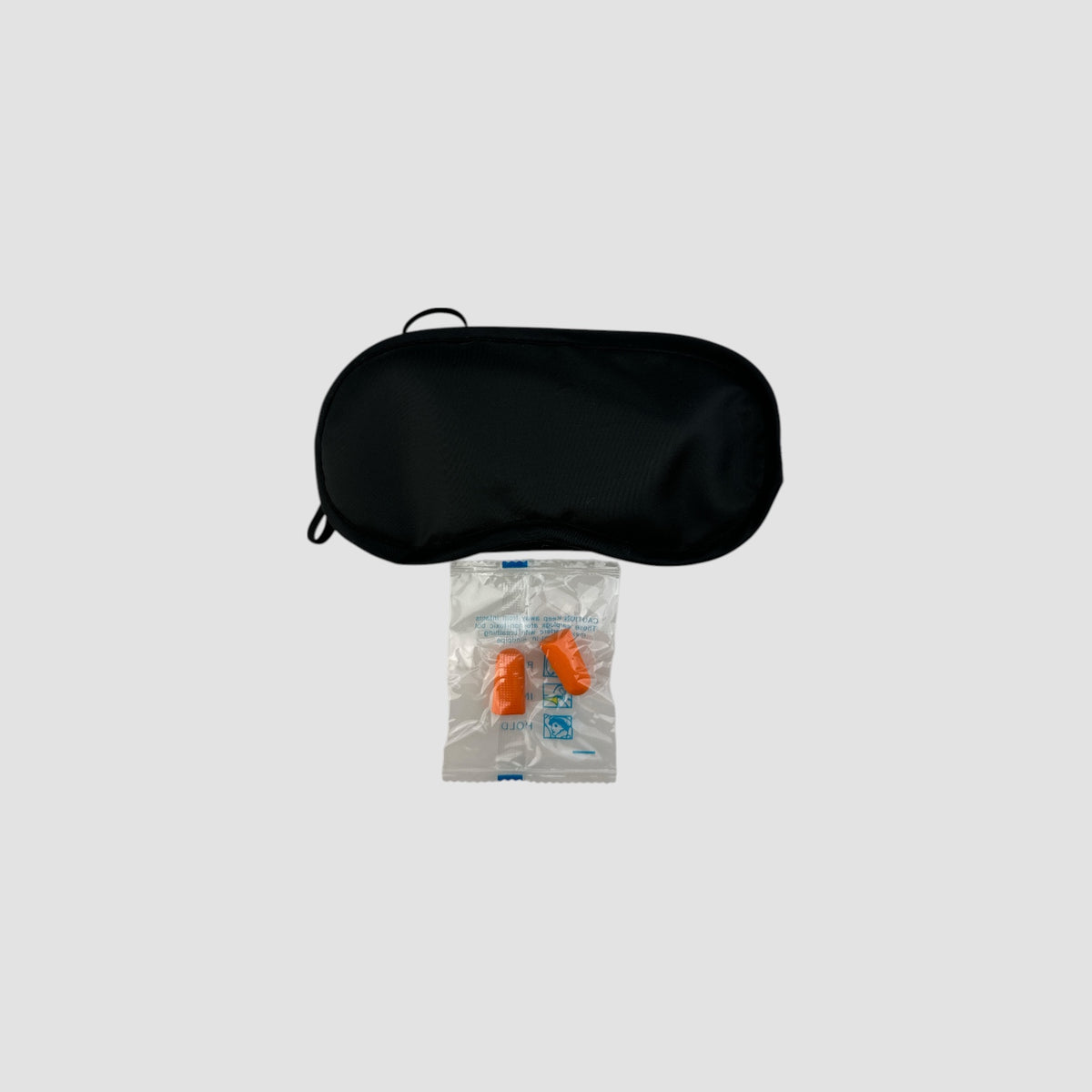 Sort sovemaske med et par orange ørepropper i pose, produktbillede