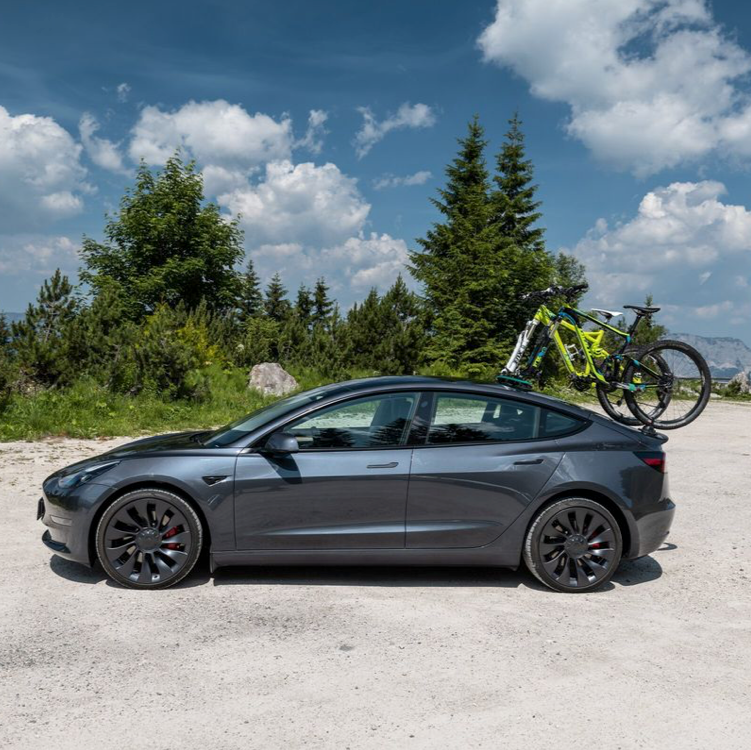 Grå Tesla med en mountainbike monteret på bagklappen med TreeFrog cykelholder udendørs