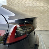 Sort ABS-performance-spoiler med coating monteret på bagklappen af en sort Tesla Model 3, med baglygte synlig