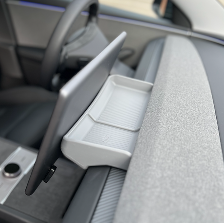 Grå opbevaringsboks monteret bag skærmen i en Tesla Model 3/Y