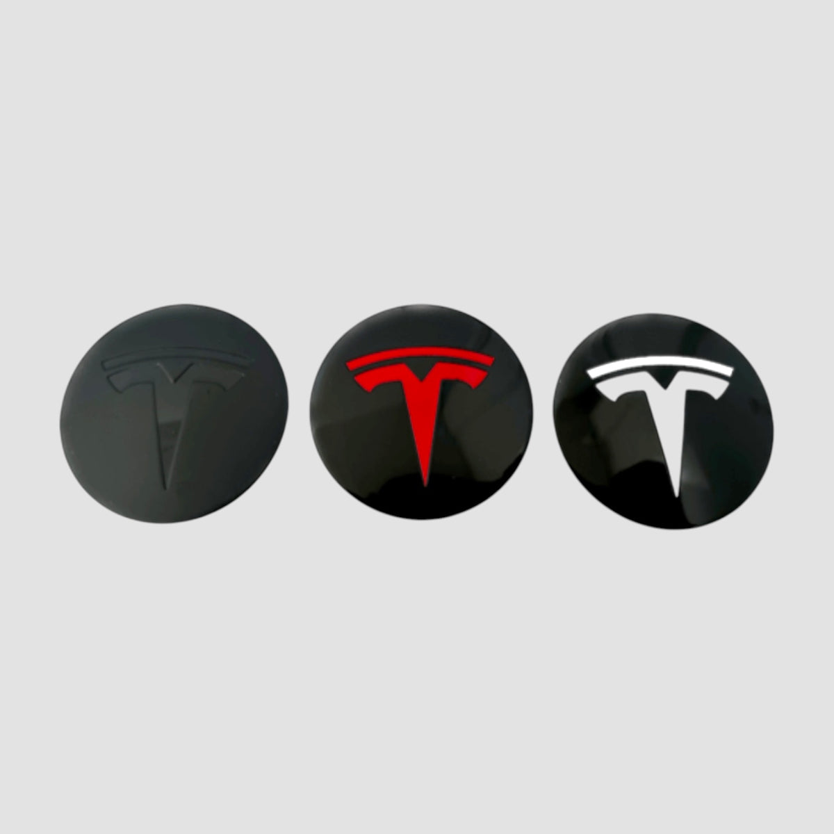 Tre centerkapsler med T-logo i sort, rødt og hvidt til MV Spiral hjulkapsler til Tesla Model Y Juniper