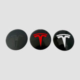 Tre centerkapsler med T-logo i sort, rødt og hvidt til MV Spiral hjulkapsler til Tesla Model Y Juniper