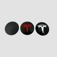 Tre Tesla centerkapsler i sort, rød og hvid til fælge.