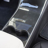 Cover i carbon-look monteret på midterkonsollen i en Tesla Model 3 før facelift