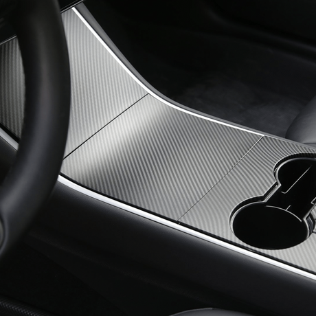 Cover i sølv carbon-look monteret på midterkonsollen i en Tesla Model 3 før facelift