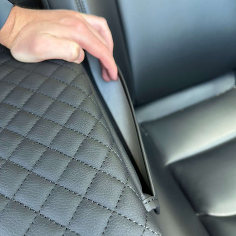 Armlæn med monteret cover åbnes med hånden i bilen