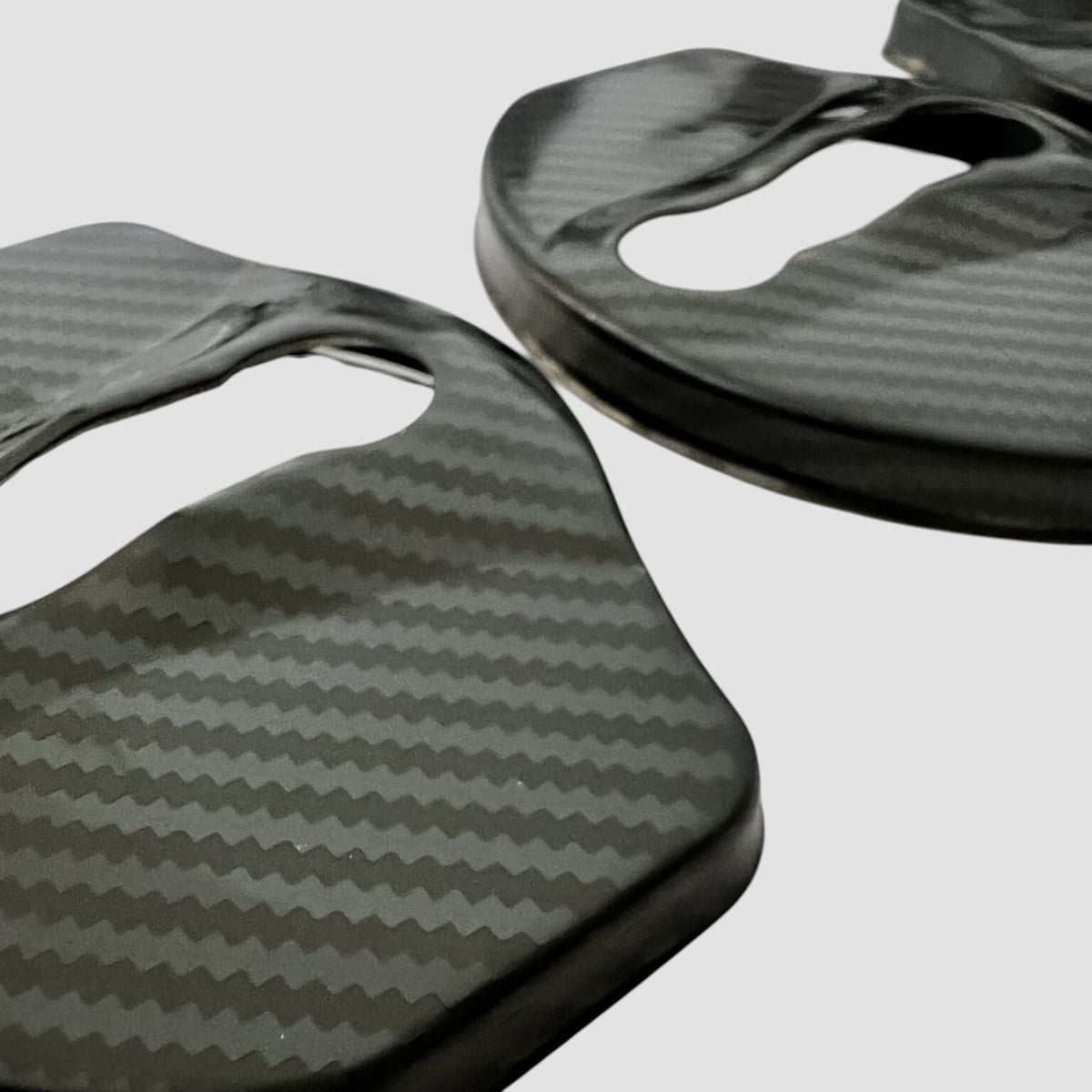 Nærbillede af dørlås covers i carbon-look til Tesla Model 3/Y på lys baggrund
