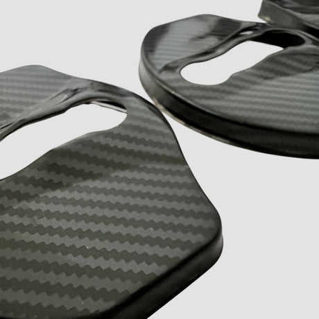 Nærbillede af dørlås covers i carbon-look til Tesla Model 3/Y på lys baggrund