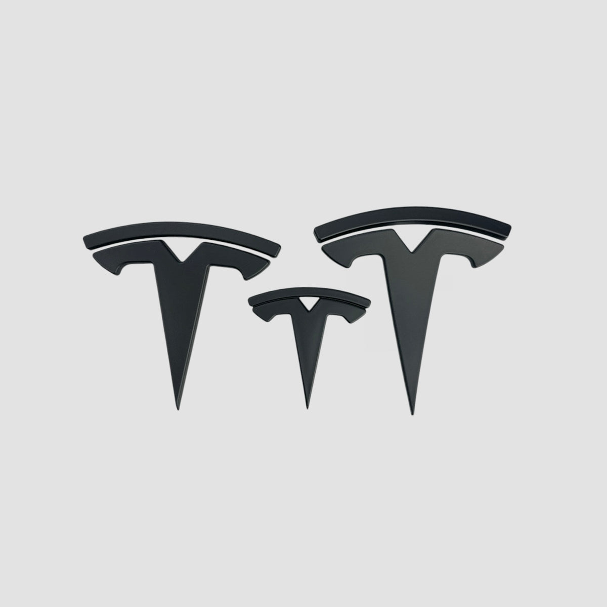 Tre Tesla T-emblem covers i mat sort i forskellige størrelser til Model 3