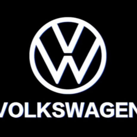 Hvidt VW-logo med teksten Volkswagen projiceret af LED-logolys på mørk baggrund