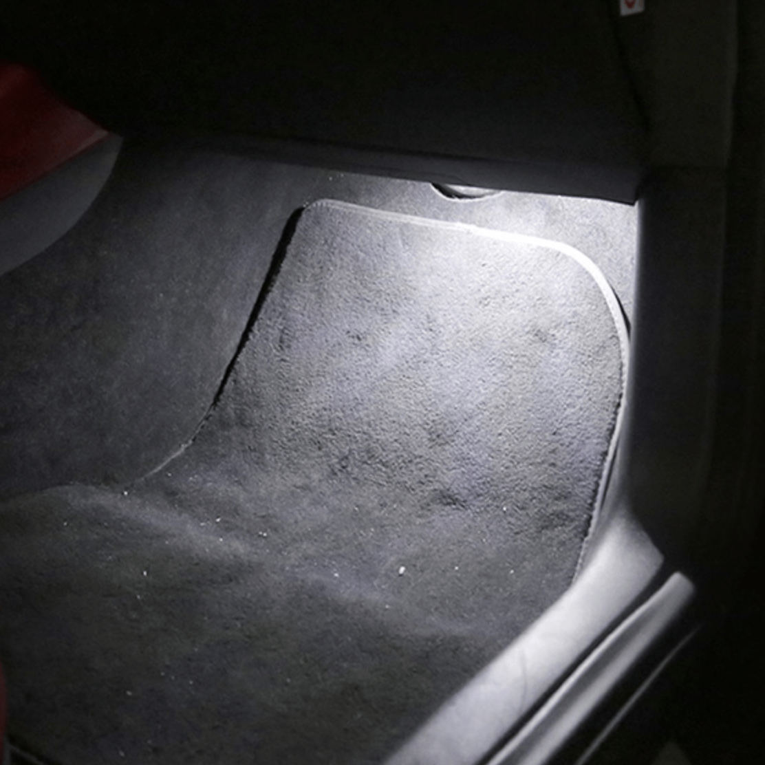 Fodrum i bilen oplyst af hvidt LED-lys der lyser gulvtæppet op