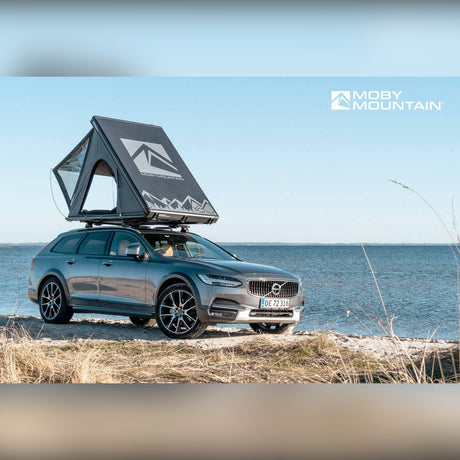 Moby Mountain Swell M tagtelt i slateGrey slået op på Volvo V90 Cross Country i klitterne set fra siden