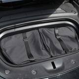 Taskesæt med to sorte opbevaringstasker i Tesla Model Y frunk.